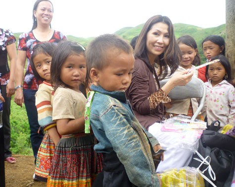 Bà VietLy Nguyen đã ân cần hỏi han và tặng quà các em học sinh. Quà tặng là quần áo mới, giầy dép mới, bánh kẹo, bánh mỳ và đồ chơi.